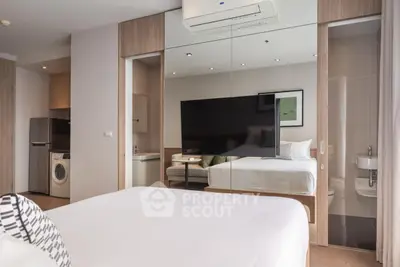 Modern bedroom with mirrored wall, washing machine, and sleek design