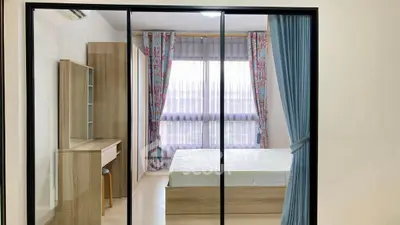 Spacious bedroom with large window and modern furnishings in a stylish apartment.