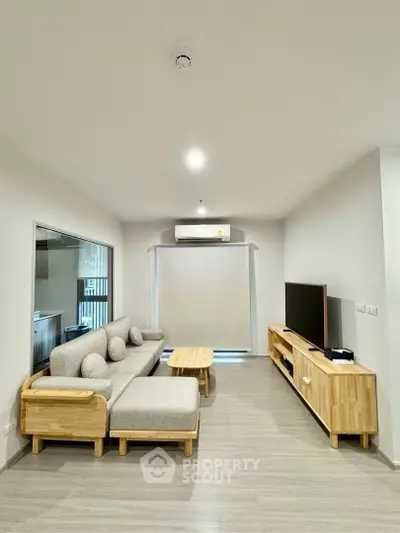 Modern living room with stylish furniture and natural light, perfect for relaxation and entertainment.