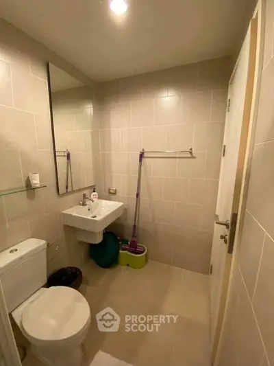 Modern bathroom with beige tiles and sleek fixtures in a contemporary apartment.