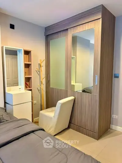 Modern bedroom with stylish wardrobe and cozy chair, perfect for urban living.