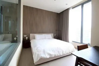 Modern bedroom with large windows and stylish decor in a contemporary apartment.