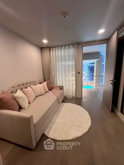 Cozy living room with elegant sofa and modern decor, featuring a view of the pool area.