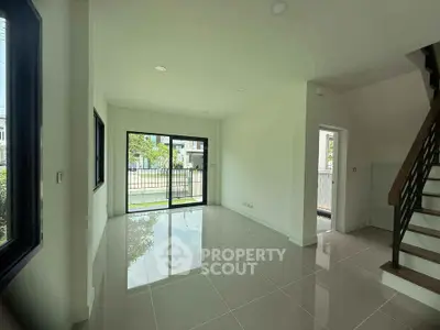 Spacious modern living room with large windows and staircase