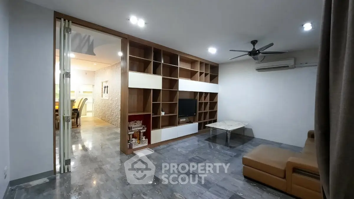 Spacious modern living room with built-in shelving and sleek furniture
