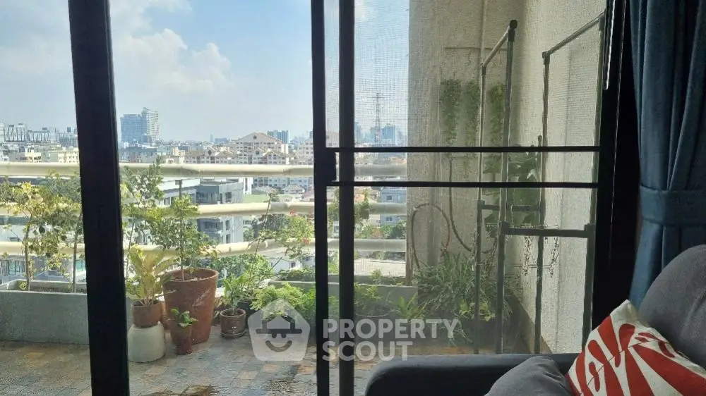 Spacious balcony with urban skyline views, offering a serene outdoor retreat in a bustling city, perfect for relaxation and entertaining.