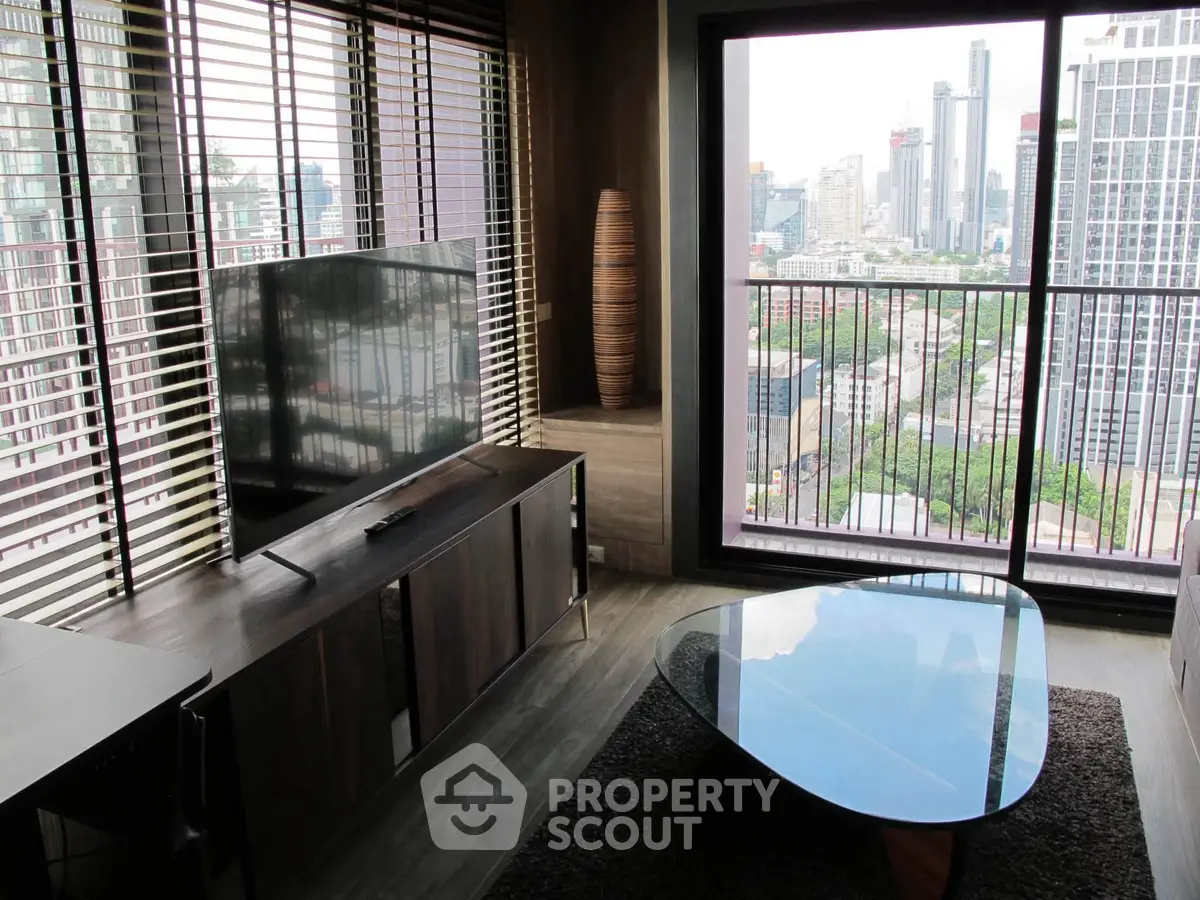 Modern living room with city view, featuring sleek furniture and large windows.