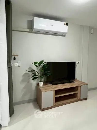 Modern living room with air conditioning and sleek TV stand, perfect for cozy entertainment.