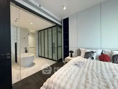 Luxurious bedroom with ensuite bathroom featuring a modern freestanding bathtub and elegant decor.