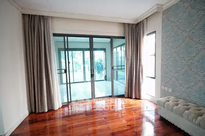 Spacious living room with elegant hardwood floors and large sliding glass doors leading to a bright balcony.