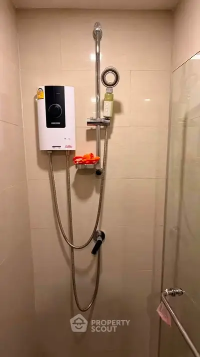 Modern bathroom shower area with water heater and glass door enclosure.