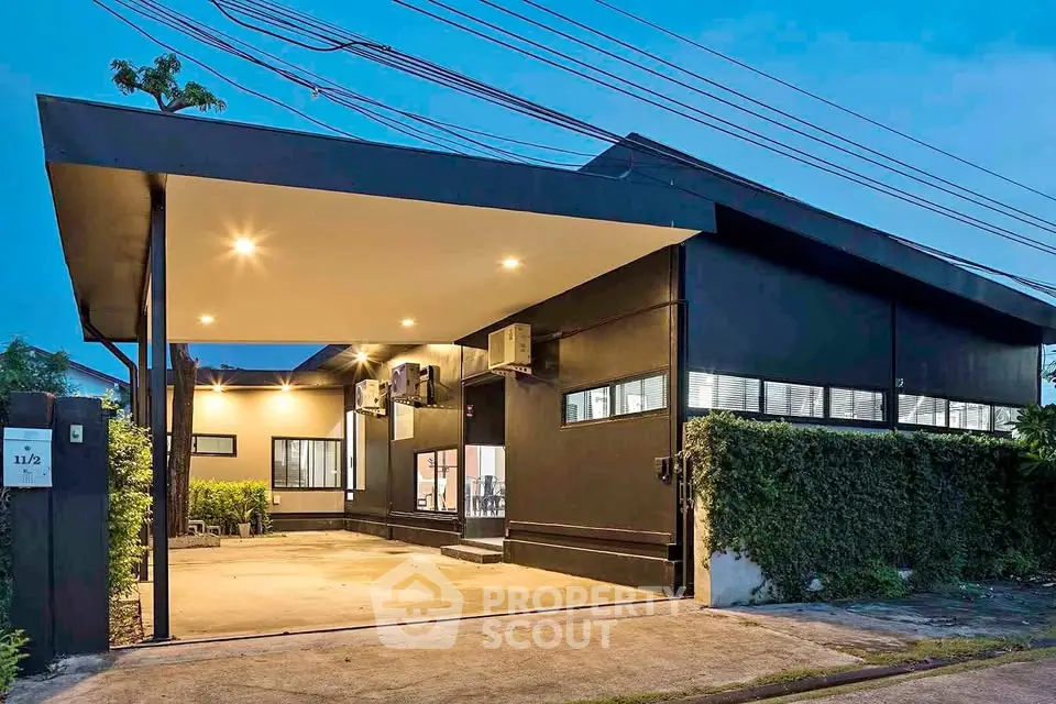 Modern single-story home with sleek black exterior and spacious driveway.