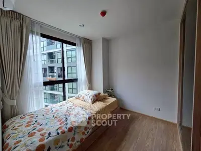 Cozy bedroom with large window and modern decor in urban apartment