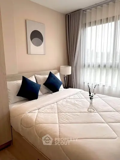 Cozy bedroom with modern decor and large window for natural light
