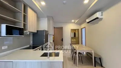 Modern kitchen with open layout, sleek appliances, and dining area in stylish apartment.