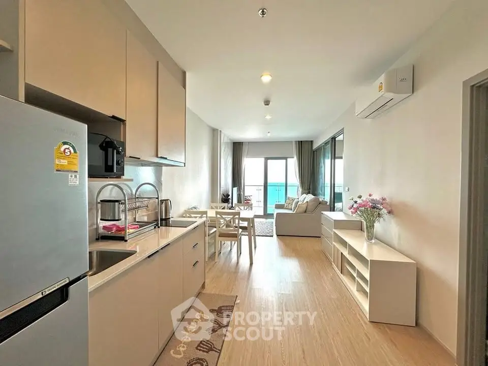 Modern open-plan kitchen and living room with balcony and sea view