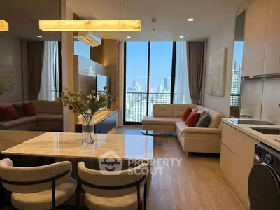 Luxurious modern living room with city view, open kitchen, and elegant decor in high-rise apartment.