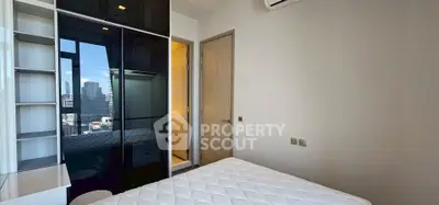 Modern bedroom with city view, featuring sleek black wardrobe and air conditioning.