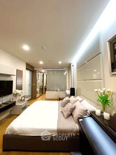 Modern bedroom with elegant decor and ambient lighting, featuring a cozy bed and stylish furnishings.