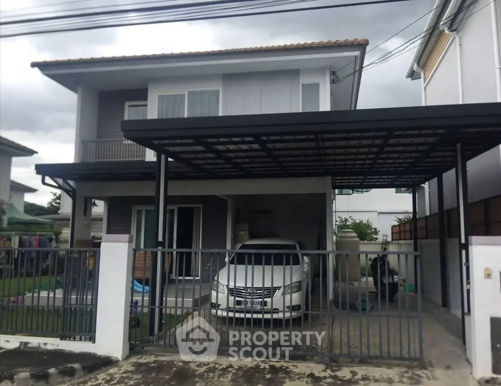 Modern two-story house with carport and gated driveway