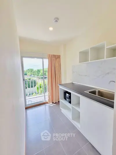 Bright kitchen with open layout and balcony view in modern apartment