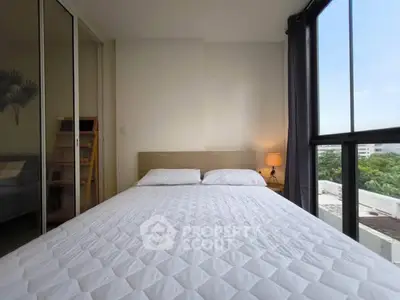 Modern bedroom with large windows and city view, featuring a cozy bed and stylish decor.