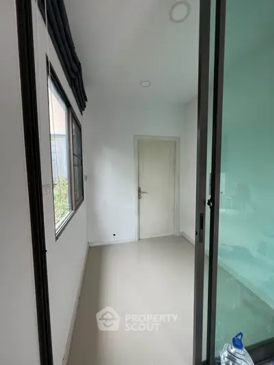 Spacious room with large window and sliding glass door, perfect for versatile use.