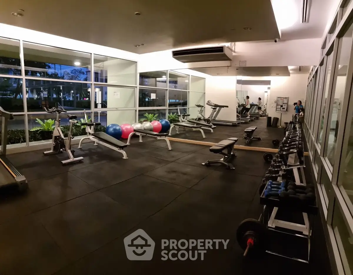 Modern gym with state-of-the-art equipment and large windows for natural light.