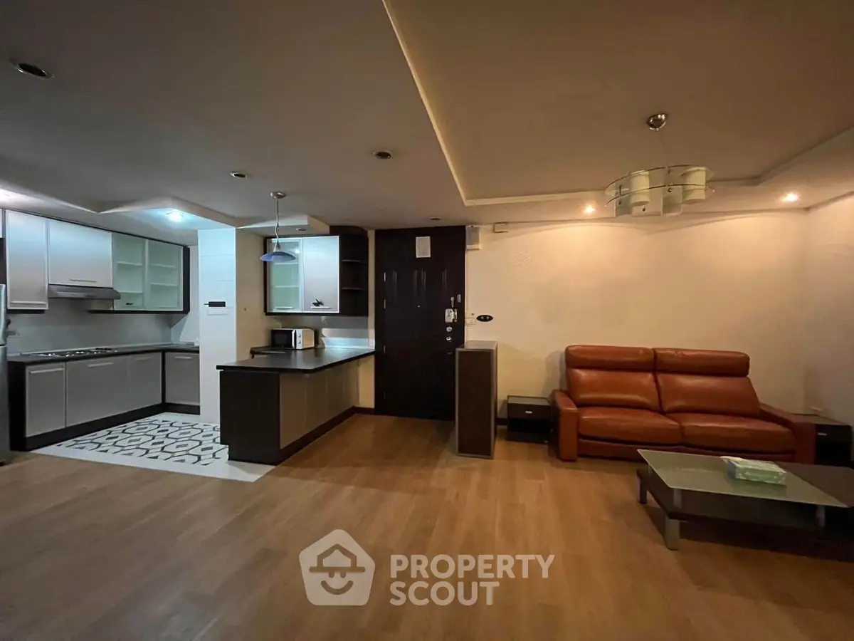 Spacious open-layout living room with modern kitchen and cozy seating area.