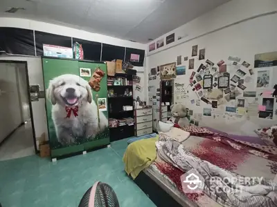 Cozy bedroom with vibrant turquoise flooring and a large bed, adorned with a unique dog-themed wardrobe, creating a personalized touch.