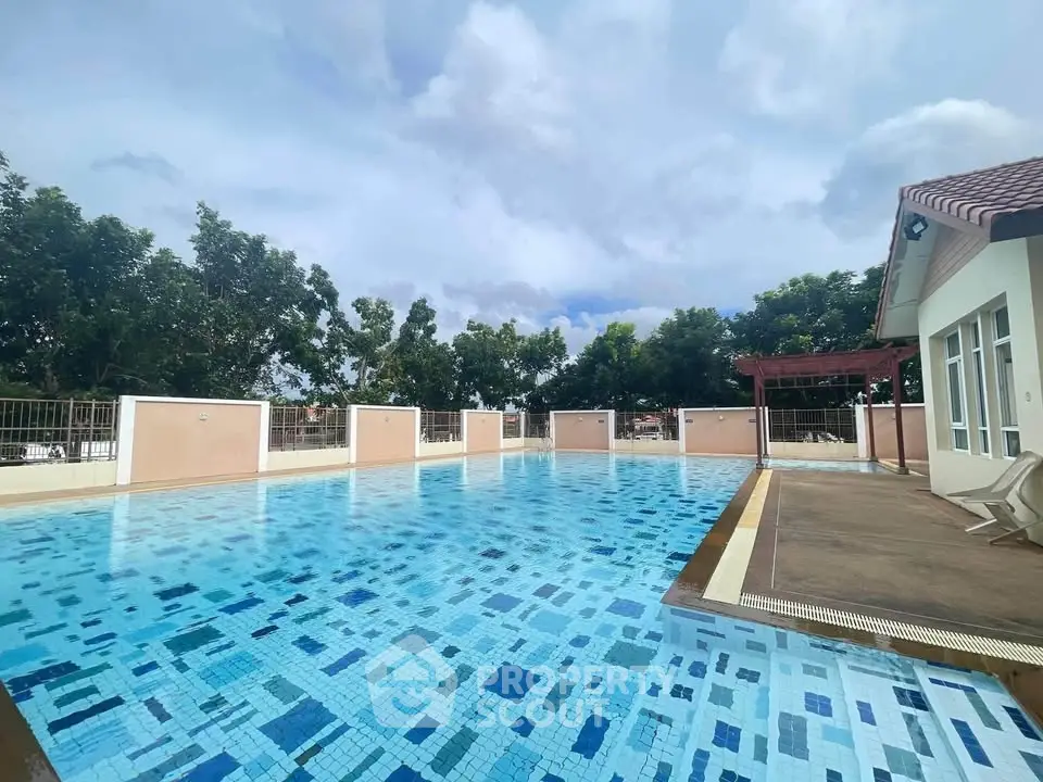 Stunning outdoor pool area with clear blue water and surrounding greenery, perfect for relaxation and leisure.