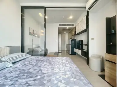 Modern bedroom with sleek design, featuring a glass partition and stylish furnishings in a contemporary apartment.