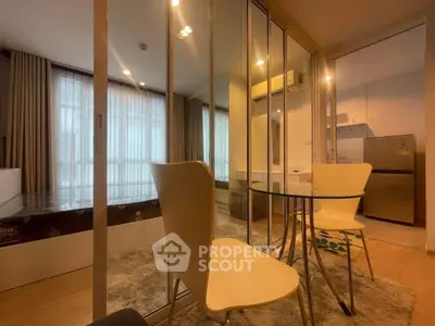 Modern studio apartment with glass partition, cozy dining area, and natural light.