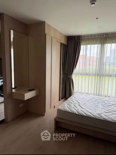 Modern bedroom with large windows and wooden flooring in a stylish apartment.