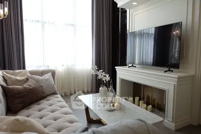 Elegant living room with plush sofa, modern TV, and chic decor, perfect for relaxation and entertainment.