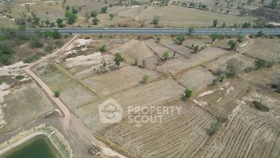 Expansive aerial view of agricultural land with road access, ideal for development opportunities.