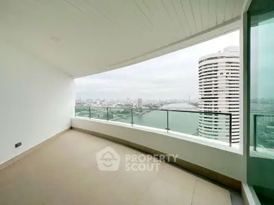 Spacious balcony with stunning city and river views in modern high-rise apartment.