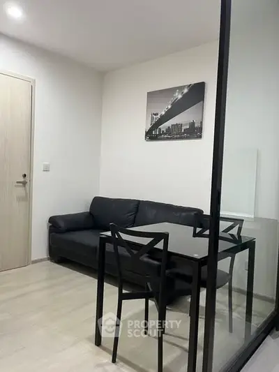Modern living room with sleek black furniture and stylish decor in a contemporary apartment.