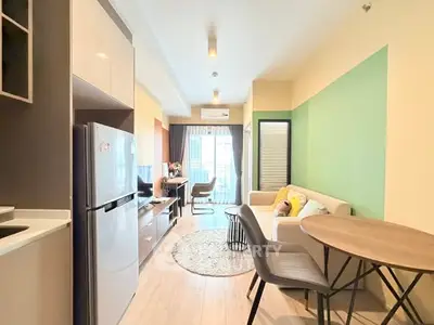 Modern living room with stylish furniture and open layout, featuring a cozy sofa and dining area.