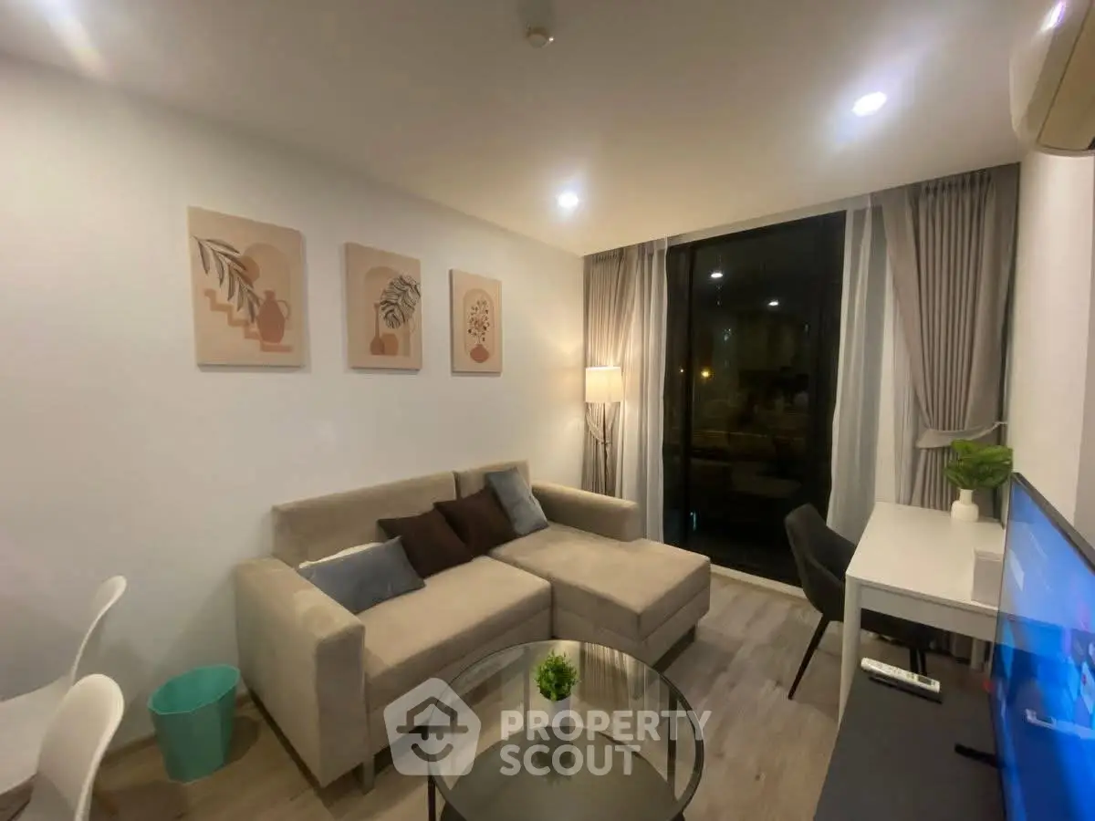 Modern living room with cozy sofa, stylish decor, and large window for natural light.