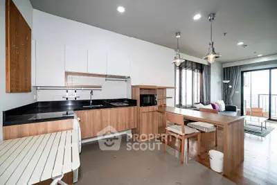 Modern open-layout kitchen and living room with stylish decor and natural light.