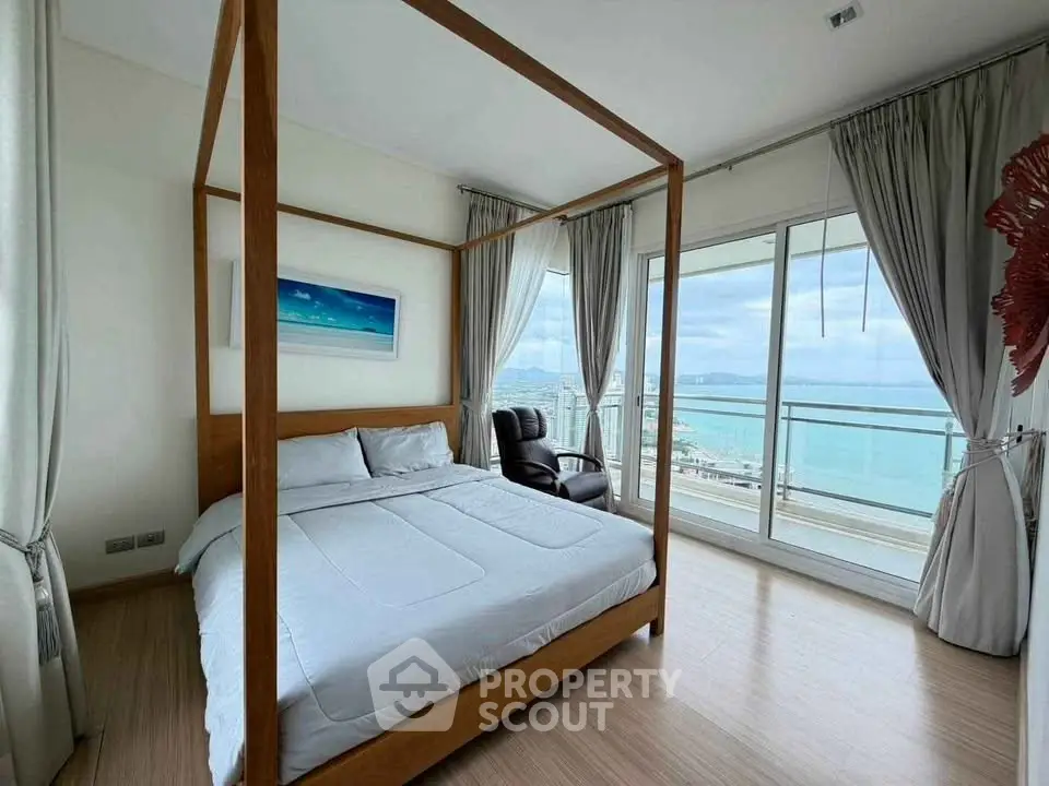 Luxurious bedroom with stunning ocean view and elegant four-poster bed in modern apartment.
