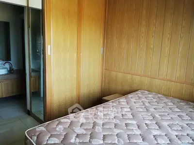 Cozy bedroom with wooden paneling and attached bathroom
