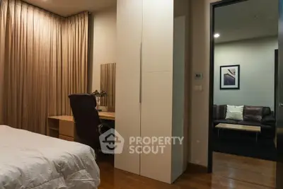 Cozy bedroom with study area and view into a stylish living room