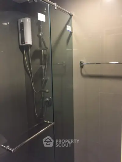 Modern bathroom with glass shower enclosure and electric water heater