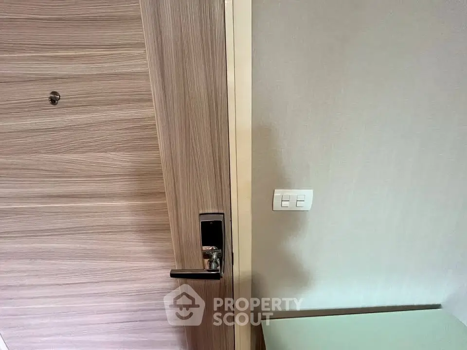 Modern apartment entrance with sleek wooden door and digital lock