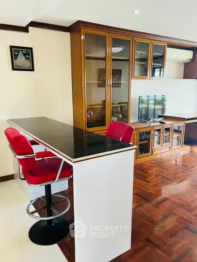 Stylish living room with parquet flooring and modern red bar stools