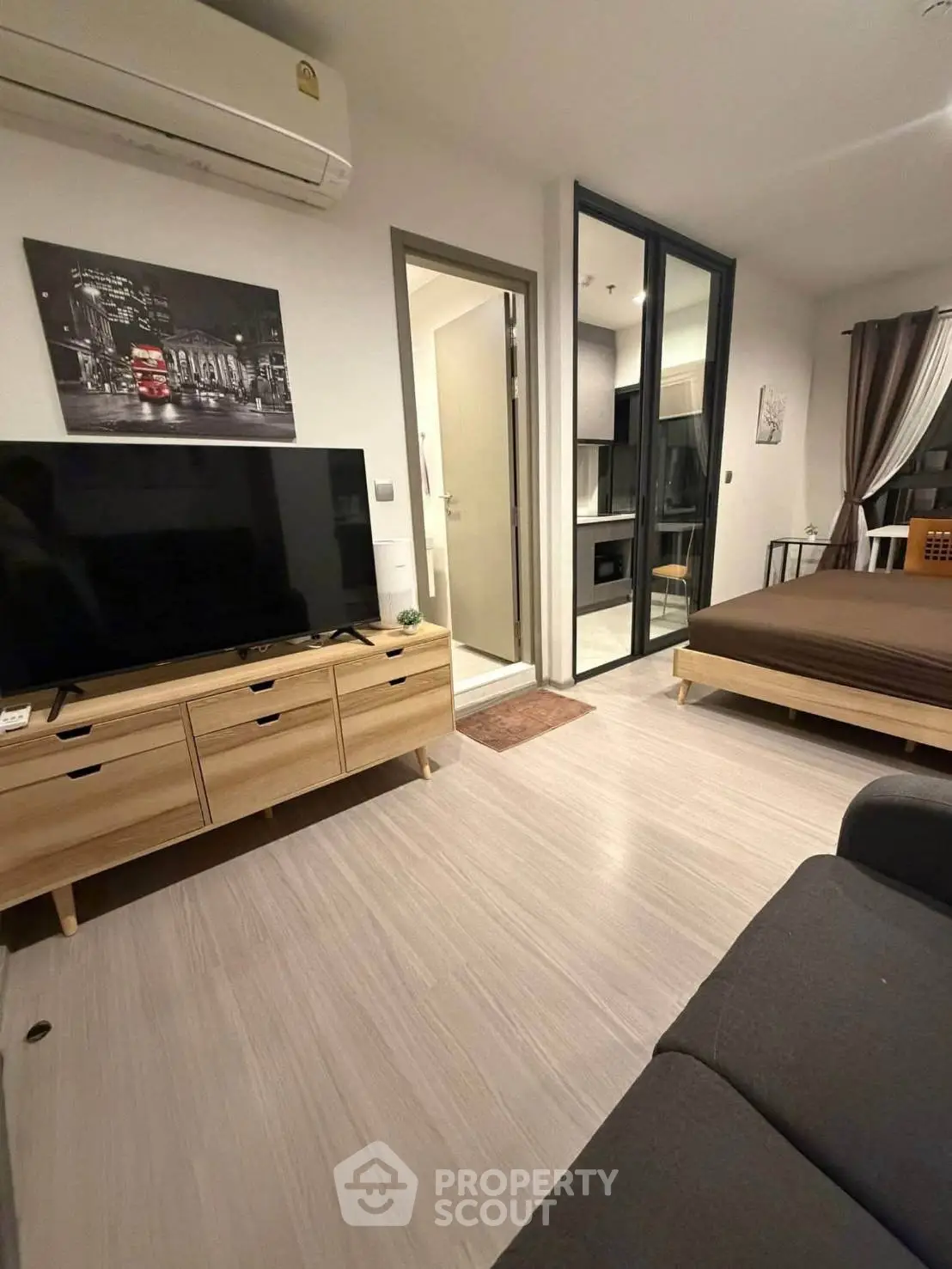 Modern studio apartment with sleek design, featuring a cozy living area and stylish bedroom.
