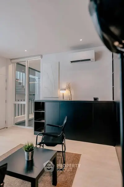 Modern living room with sleek black furniture and natural light