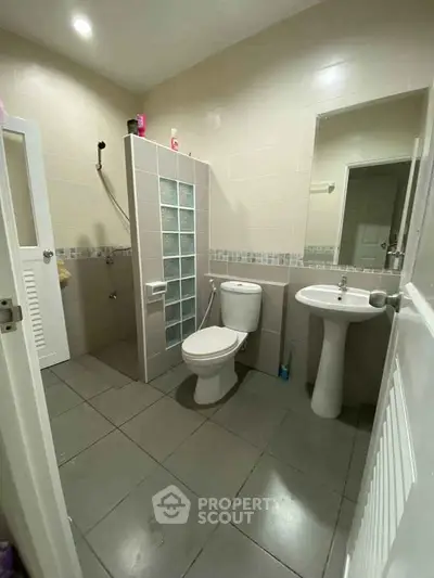 Modern bathroom with glass block partition and sleek fixtures